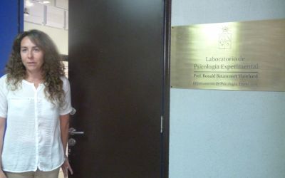 La prof(a) Vanetza Quezada presentando la placa con el nuevo nombre del laboratorio.